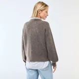 Cárdigan de punto grueso en color marrón, con cuello redondo, cierre frontal de botones y mangas largas con puños ajustados.