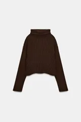 Jersey de punto acanalado color marrón oscuro, con cuello subido, manga larga y bajo con aberturas laterales.