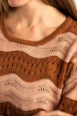 Sweater de tejido de punto con diseño de rayas horizontales onduladas en tonos marrón y beige. Presenta cuello redondo, mangas largas y corte oversize.