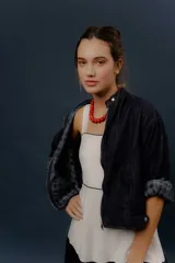 Campera de denim azul oscuro, de corte corto y estilo bomber, con cierre frontal y detalles de forrería a cuadros visibles en el interior de los puños.