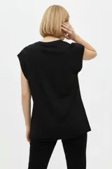 Remera negra de algodón, con cuello redondo, mangas cortas holgadas con vuelta y estampa floral grande en el pecho.
