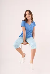 Pijama de dos piezas color coral, compuesto por una remera de manga corta con botones y un pantalón capri estampado con flores.