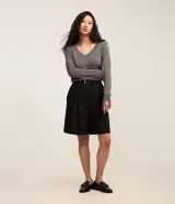 Suéter de punto color amarillo, con escote en V y mangas largas. Presenta un diseño básico y versátil, confeccionado en una mezcla de viscosa, poliamida y elastano.