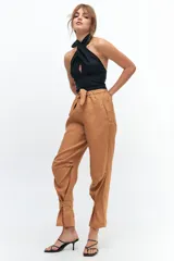 Pantalón de lino color marrón claro, con corte recto, cintura alta con lazo ajustable, elástico en la parte trasera y presillas en las piernas.