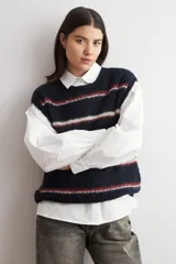 Chaleco de tejido de punto sin mangas, con diseño de rayas horizontales en azul marino, blanco y rojo. Presenta cuello redondo y terminaciones acanaladas.