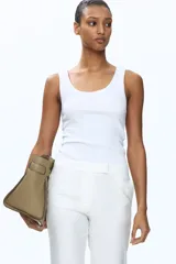 Pantalón sastrero blanco de pernera ancha y recta, con pliegues frontales marcados.