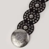 Cinto negro con apliques circulares plateados.