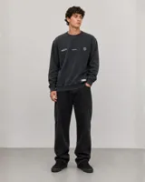 Buzo de cuello redondo con diseño oversize, confeccionado en algodón con efecto lavado. Presenta detalles gráficos estampados en el pecho y etiqueta decorativa en el ruedo.