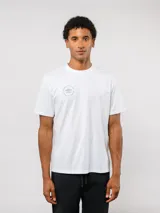 Remera de manga corta color blanco con cuello redondo. Presenta un pequeño logo circular de Umbro estampado en el pecho con la leyenda 'Born to Play'.