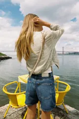 Cazadora de cuello redondo y manga larga, color verde claro con patrón a cuadros. Confeccionada en tejido de organza con estructura y acabados elásticos. Cierre frontal con cremallera y bolsillos delanteros.