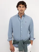 Camisa de micropana celeste para hombre, de corte regular fit y manga larga. Cuenta con cuello abotonado, cierre frontal con botones y detalle de vivo liso en el interior de los puños.