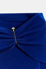 Top de punto color crema con escote recto estilo hombros descubiertos, manga larga y detalle de hebilla metálica en el hombro.
