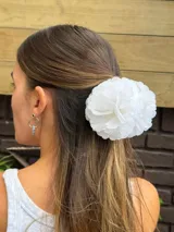Pinza para el pelo con diseño de flores blancas grandes estilo clavel, con mecanismo de agarre tipo clip en tono beige.