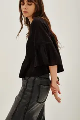 Camisa de algodón color negro, con cuello redondo, mangas tres cuartos abullonadas y detalles de encaje y alforzas en el frente y mangas.