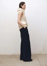 Pantalón de vestir negro, de corte wide leg, tiro medio, con trabillas y pinzas frontales. Cierre frontal oculto con botón, gancho y cremallera. Confeccionado en tejido mezcla de lana con forro interior.