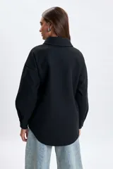 Sobrecamisa de paño en color negro, con cuello clásico, cierre frontal de botones y bolsillos frontales con solapa.