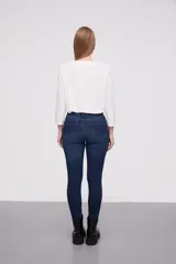 Pantalon jean de corte skinny y tiro alto, color azul clásico con costuras en tono ocre.