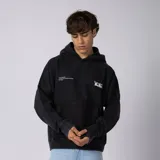 Buzo canguro negro de algodón rústico con efecto lavado washed, capucha, bolsillo canguro y estampa frontal en blanco. Cuenta con aberturas para el pulgar en los puños.