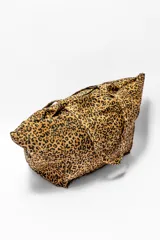 Bolso tipo tote con diseño amplio y estampado animal print de leopardo en tonos marrones y negros. Cuenta con doble asa superior y un bolsillo frontal con solapa.