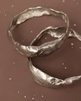 Brazalete rígido de diseño orgánico con textura irregular y acabado brillante, elaborado artesanalmente en metales nobles.