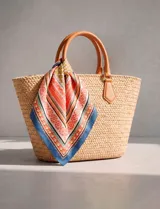 Pañuelo cuadrado de satén con estampado geométrico y floral en tonos rojizos, azul y beige. Presenta un diseño versátil ideal para accesorios.