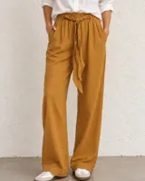 Pantalón holgado color tostado de corte recto, con cintura elástica fruncida y lazo ajustable del mismo tejido. Cuenta con bolsillos laterales.