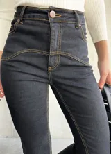 Pantalón de jean negro con costuras a la vista color ocre.