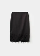 Falda midi recta de color negro, confeccionada en poliéster con forro interior, que presenta un detalle de adorno con cristales colgantes en el bajo.