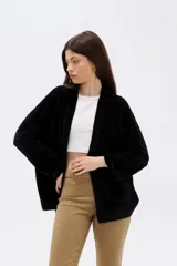 Saco abierto de tejido tipo chenille, color negro, con diseño holgado, manga larga y bolsillos frontales.