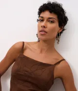 Vestido midi de gamuza sintética color marrón, con diseño de bordado de follaje en relieve. Presenta escote recto, tirantes finos regulables, ajuste al cuerpo, espalda con lastex y abertura frontal en la falda.