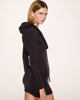 Minivestido negro con capucha, mangas largas y cordones laterales ajustables.