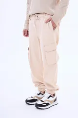 Pantalón cargo de gabardina color negro, con bolsillos laterales tipo cargo, cintura elástica con cordón ajustable y puños elásticos en los tobillos.