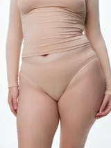 Bombacha tipo vedetina de diseño seamless, confeccionada en microfibra color beige. Presenta un corte de tiro bajo con acabado suave y elástico, ideal para un uso diario confortable.