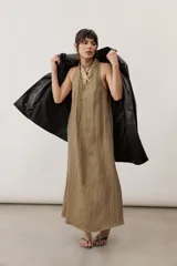 Chaqueta negra de cuero con cuello camisero, mangas largas y costuras decorativas.