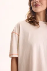 Remera de algodón blanca de manga corta, diseño cropped y calce cómodo. Cuenta con tajos laterales y costuras a contratono en color celeste.