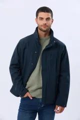 Campera de neopreno color azul marino, con cuello alto que incluye capucha oculta, cierre frontal con botones a presión y cremallera, bolsillos laterales y bolsillo vertical en el pecho.