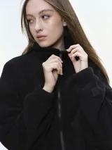 Campera de tela fleece doble, color negro, con cierre frontal completo, cuello alto y bolsillos laterales. Presenta puños y bajo elastizados para un ajuste cómodo.