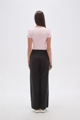 Remera cropped de color rosado con cuello redondo y detalles de costuras en color marrón. Presenta un bordado frontal con el número 94 y estrellas.