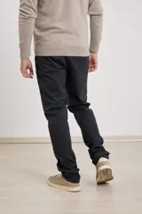 Pantalón chino de hombre color verde oscuro, corte slim, confeccionado en algodón con elastano, con triple pespunte en las costuras y botones al tono.