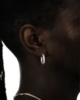 Aro de plata con forma de argolla con textura irregular.