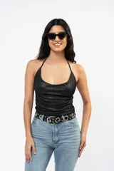 Top halter de tela metalizada negra con escote drapeado y espalda descubierta.