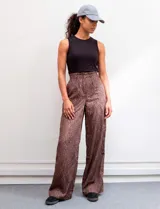 Pantalón wide leg de tiro alto con estampado animal print en tonos marrones. Presenta pretina ancha, cierre frontal con broche y bolsillos laterales aplicados.