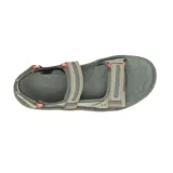 Sandalia de senderismo Merrell modelo Huntington Sport, color gris con detalles en naranja. Presenta un diseño sintético resistente al agua con sistema de ajuste de velcro, plantilla de espuma EVA, tecnología Air Cushion en el talón para absorción de impactos y suela de goma con tracción.