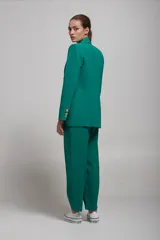 Pantalón de vestir verde esmeralda con pinzas, corte recto y bolsillos laterales.