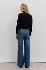 Sweater de punto color negro, con cuello alto y mangas largas de corte raglán.