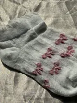 Medias blancas de tejido texturizado con rombos en relieve y borde superior con volados.