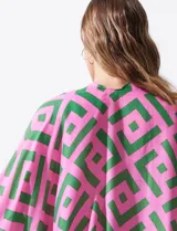Kimono ligero de poliéster con estampado geométrico en tonos rosa y verde, mangas cortas y terminación con borlas verdes en el ruedo.