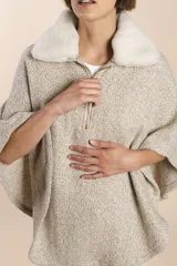 Poncho color crema con cuello de corderito desmontable y cierre dorado.