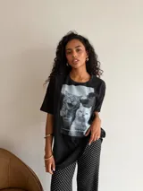 Remeron de algodón color marrón con estampa frontal de dos gatos bebiendo café. Presenta un corte oversize, cuello redondo y mangas cortas.