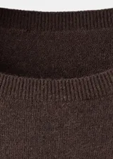 Vestido corto de tejido de punto fino, con cuello redondo, diseño recto y manga larga.